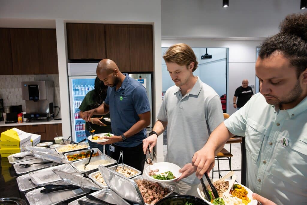 Construction team members serving food and sharing a meal during workplace wellness event