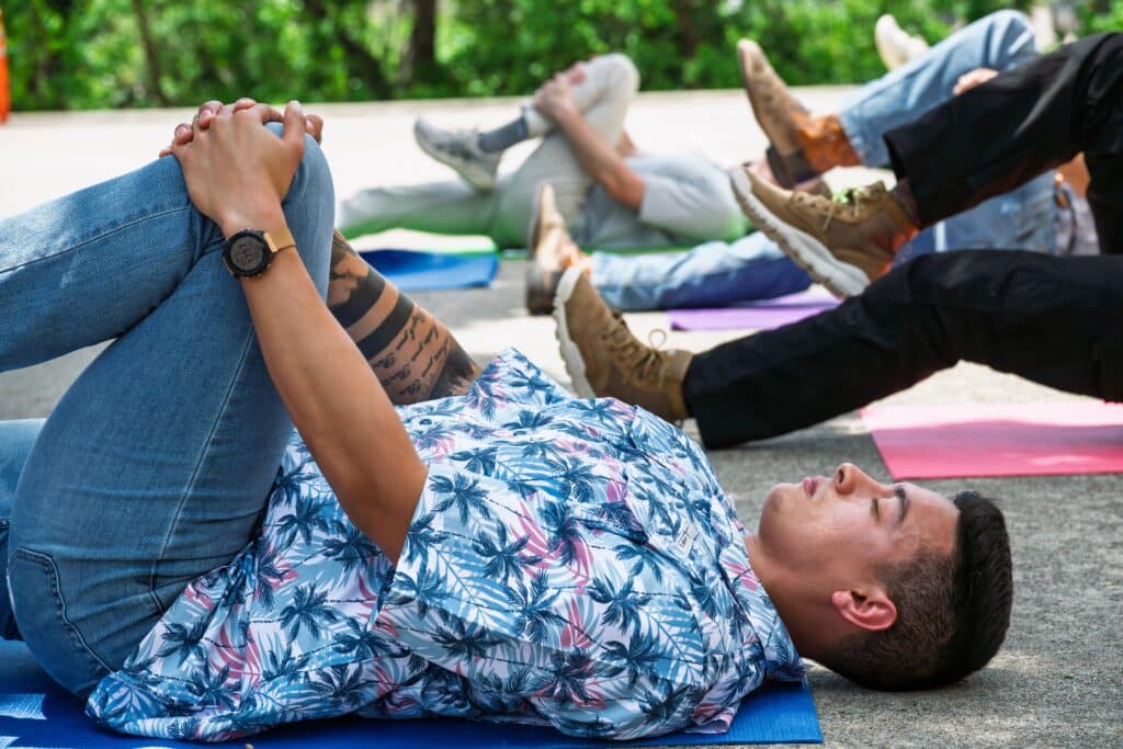 employees stretching on mats outdoor workplace wellness event