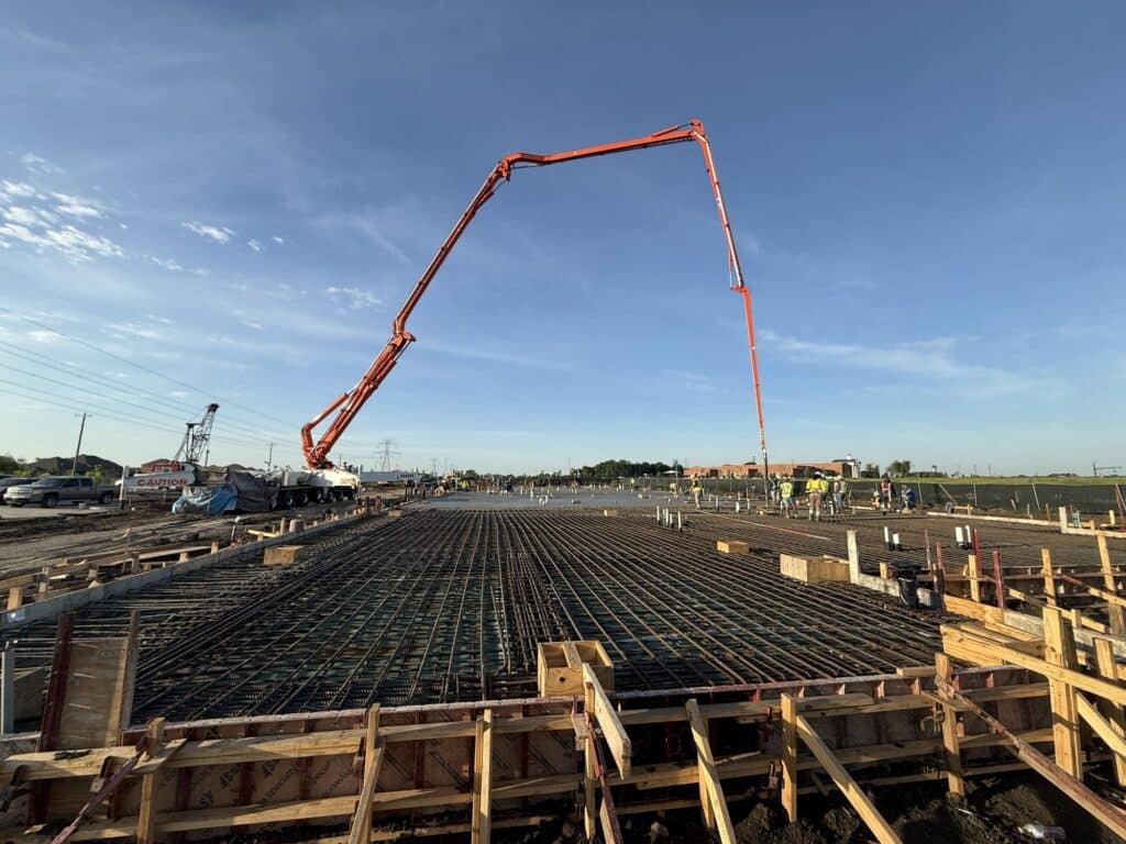 A concrete pump places concrete across the reinforced structural slab at the TMI Sports Medicine ASC project in Grand Prairie.