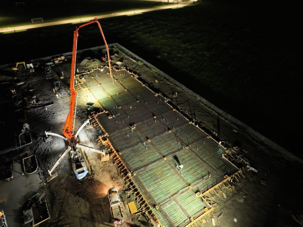 Nighttime foundation concrete pour underway with crews placing concrete for the TMI Sports Medicine ASC in Grand Prairie.